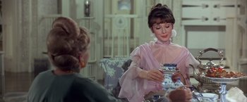 Movie still from “My Fair Lady” (1964), directed by George Cukor – Two women sitting at a table with a tea pot; Medium shot, Over the shoulder angle
