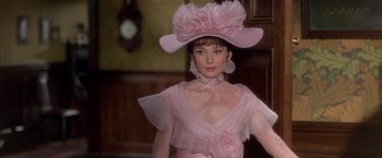 Movie still from “My Fair Lady” (1964), directed by George Cukor – A woman in a pink dress and a pink hat; Close Up shot, Over the shoulder angle