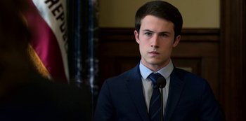 Movie still from “13 Reasons Why” (2017), created by Brian Yorkey – A man in a suit and tie in front of a judge; Close Up shot, Over the shoulder angle