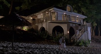 Movie still from “My Father the Hero” (1994), directed by Steve Miner – Two people walking in front of a house at night; Extreme Wide shot, Low angle