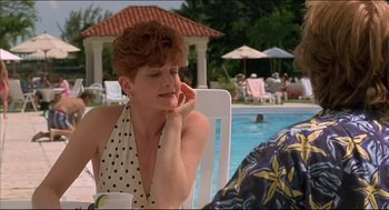 Movie still from “My Father the Hero” (1994), directed by Steve Miner – A woman sitting in a chair next to a swimming pool; Medium shot, Over the shoulder angle