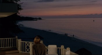 Movie still from “My Father the Hero” (1994), directed by Steve Miner – A person sitting on a deck looking out at the ocean; Extreme Wide shot, Over the shoulder angle