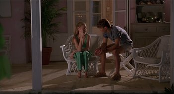 Movie still from “My Father the Hero” (1994), directed by Steve Miner – A man and a woman sitting on a white chair; Medium shot, High angle