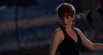 Movie still from “My Father the Hero” (1994), directed by Steve Miner – A woman in a black dress standing on a street at night; Medium shot, Low angle