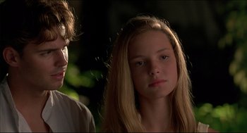 Movie still from “My Father the Hero” (1994), directed by Steve Miner – A young girl with long blonde hair standing next to a young man; Close Up shot, Over the shoulder angle
