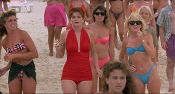 Movie still from “My Father the Hero” (1994), directed by Steve Miner – A group of women in bathing suits walking on the beach; Medium shot, High angle