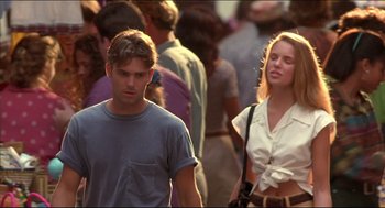 Movie still from “My Father the Hero” (1994), directed by Steve Miner – A man and a woman walking down a crowded street; Medium shot, Over the shoulder angle