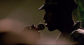 Movie still from “My Father the Hero” (1994), directed by Steve Miner – A man with a hat is singing into a microphone; Close Up shot, Low angle