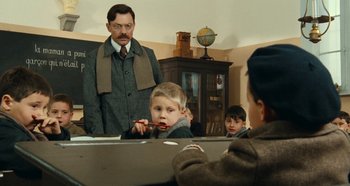 Movie still from “My Father's Glory” (1990), directed by Yves Robert – A group of people sitting in a room; Medium shot, Over the shoulder angle