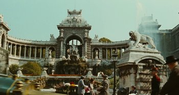 Movie still from “My Father's Glory” (1990), directed by Yves Robert – A group of people standing in front of an ornate building; Extreme Wide shot, Low angle