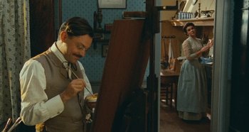 Movie still from “My Father's Glory” (1990), directed by Yves Robert – A man painting a picture in front of a woman; Wide shot, Low angle
