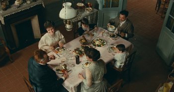 Movie still from “My Father's Glory” (1990), directed by Yves Robert – A family sitting at a dinner table eating a meal; Wide shot, High angle