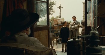 Movie still from “My Father's Glory” (1990), directed by Yves Robert – A man standing next to a woman and a donkey; Wide shot, Over the shoulder angle