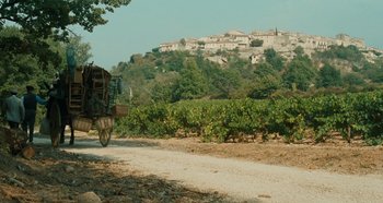 Movie still from “My Father's Glory” (1990), directed by Yves Robert – A horse drawn carriage traveling down a dirt road; Extreme Wide shot, High angle