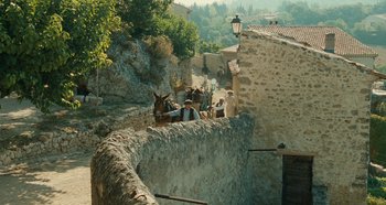 Movie still from “My Father's Glory” (1990), directed by Yves Robert – A group of people riding horses down the side of a stone wall; Extreme Wide shot, High angle