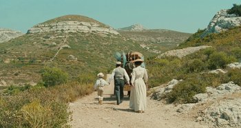 Movie still from “My Father's Glory” (1990), directed by Yves Robert – A group of people walking down a dirt road; Extreme Wide shot, High angle
