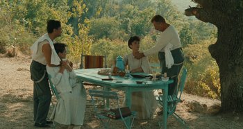 Movie still from “My Father's Glory” (1990), directed by Yves Robert – A group of people sitting around a table; Wide shot, High angle