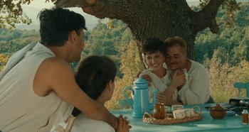 Movie still from “My Father's Glory” (1990), directed by Yves Robert – A group of people sitting around a table; Medium shot, Over the shoulder angle