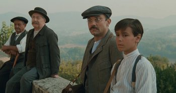 Movie still from “My Father's Glory” (1990), directed by Yves Robert – A group of people standing next to each other on top of a hill; Medium shot, Low angle