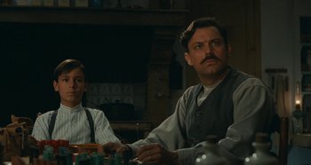 Movie still from “My Father's Glory” (1990), directed by Yves Robert – A man and a woman sitting at a dinner table; Medium shot, Low angle