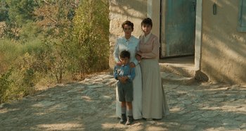 Two women and a boy standing in front of a building