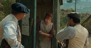 Movie still from “My Father's Glory” (1990), directed by Yves Robert – A woman standing in the doorway of a building; Medium shot, Over the shoulder angle