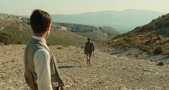 Movie still from “My Father's Glory” (1990), directed by Yves Robert – Two people are walking on a rocky path; Wide shot, Low angle
