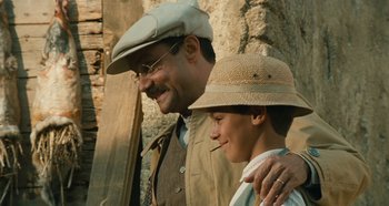 Movie still from “My Father's Glory” (1990), directed by Yves Robert – A man and a young boy standing next to each other; Medium shot, Low angle