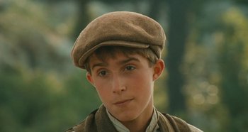 Movie still from “My Father's Glory” (1990), directed by Yves Robert – A young man wearing a brown hat and a brown jacket; Close Up shot, High angle