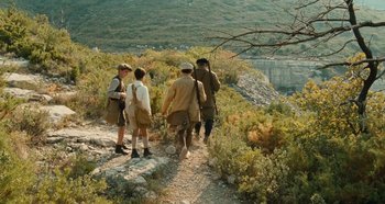 Movie still from “My Father's Glory” (1990), directed by Yves Robert – A group of people walking up a hill; Wide shot, High angle