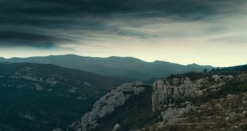 Movie still from “My Father's Glory” (1990), directed by Yves Robert – A view of a mountain range with a cloudy sky above it; Extreme Wide shot, Low angle
