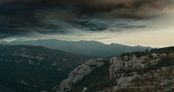 Movie still from “My Father's Glory” (1990), directed by Yves Robert – A view of a mountain range with a cloudy sky above it; Extreme Wide shot, Low angle