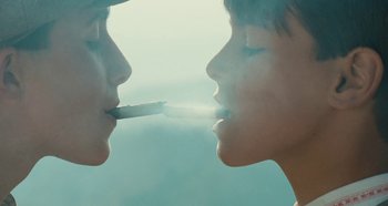 Movie still from “My Father's Glory” (1990), directed by Yves Robert – Two people are smoking a joint in the air; Extreme Close Up shot, Overhead angle