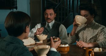 Movie still from “My Father's Glory” (1990), directed by Yves Robert – Three people sitting at a table eating food; Medium shot, High angle