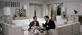 Movie still from “My Geisha” (1962), directed by Jack Cardiff – Two men sitting at a table in a living room; Wide shot, High angle