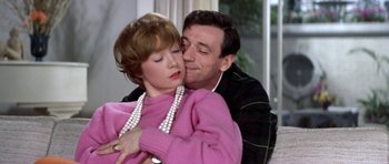 Movie still from “My Geisha” (1962), directed by Jack Cardiff – A man and a woman embracing each other in front of a window; Close Up shot, Low angle