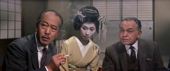 Movie still from “My Geisha” (1962), directed by Jack Cardiff – An old man and two men smoking a cigarette; Close Up shot, Over the shoulder angle