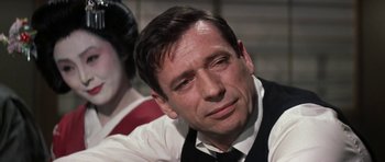 Movie still from “My Geisha” (1962), directed by Jack Cardiff – A person wearing a suit and tie; Close Up shot, Over the shoulder angle
