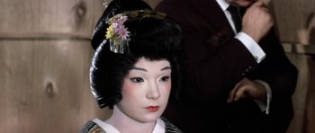 Movie still from “My Geisha” (1962), directed by Jack Cardiff – A geisha doll wearing a black and white outfit; Close Up shot, High angle