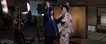 Movie still from “My Geisha” (1962), directed by Jack Cardiff – A man and a geisha in a photo studio; Medium shot, Over the shoulder angle