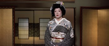 Movie still from “My Geisha” (1962), directed by Jack Cardiff – A geisha in a kimono is standing in front of a mirror; Medium shot, Low angle