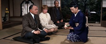 Movie still from “My Geisha” (1962), directed by Jack Cardiff – A group of people sitting on the ground; Medium shot, High angle