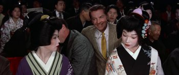 Movie still from “My Geisha” (1962), directed by Jack Cardiff – A group of men and women standing next to each other; Medium shot, Low angle