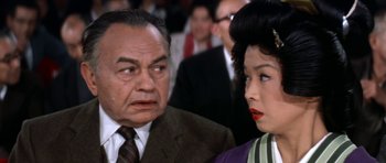 Movie still from “My Geisha” (1962), directed by Jack Cardiff – An older man and a younger woman are looking at each other; Close Up shot, Over the shoulder angle