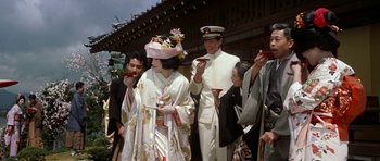 Movie still from “My Geisha” (1962), directed by Jack Cardiff – A group of people standing next to each other; Medium shot, Low angle