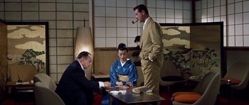 Movie still from “My Geisha” (1962), directed by Jack Cardiff – A man in a suit and tie standing next to a woman in a kimono; Medium shot, High angle