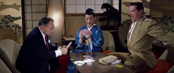 Movie still from “My Geisha” (1962), directed by Jack Cardiff – A man and a woman sitting at a table playing a card game; Medium shot, High angle
