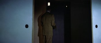 Movie still from “My Geisha” (1962), directed by Jack Cardiff – A man in a suit standing in front of an open door; Wide shot, Low angle
