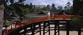Movie still from “My Geisha” (1962), directed by Jack Cardiff – A man standing on top of a wooden bridge over a river; Extreme Wide shot, High angle