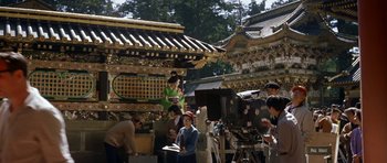 Movie still from “My Geisha” (1962), directed by Jack Cardiff – A group of people standing next to each other on a street; Wide shot, High angle